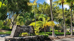 Señal para el Keauhou Kona Surf and Spa Resort, con muro de piedra y vegetación tropical.