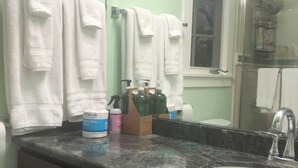 Un baño con lavamanos, espejo y toallas.