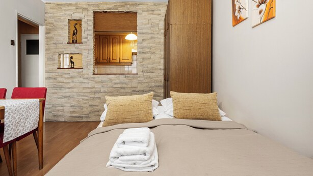 Un dormitorio con pared de piedra, aparador de madera y una obra de arte.