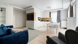 A modern apartment with a living room, kitchen, dining area, and a TV. - Bielany Spacious Apartment (Warszawa)