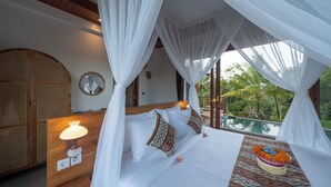 A bedroom with a canopy bed, a bedside lamp, a clock, and a view of the outdoors. - Casa Fortuna Villa by Mahaputra (Sebatu)