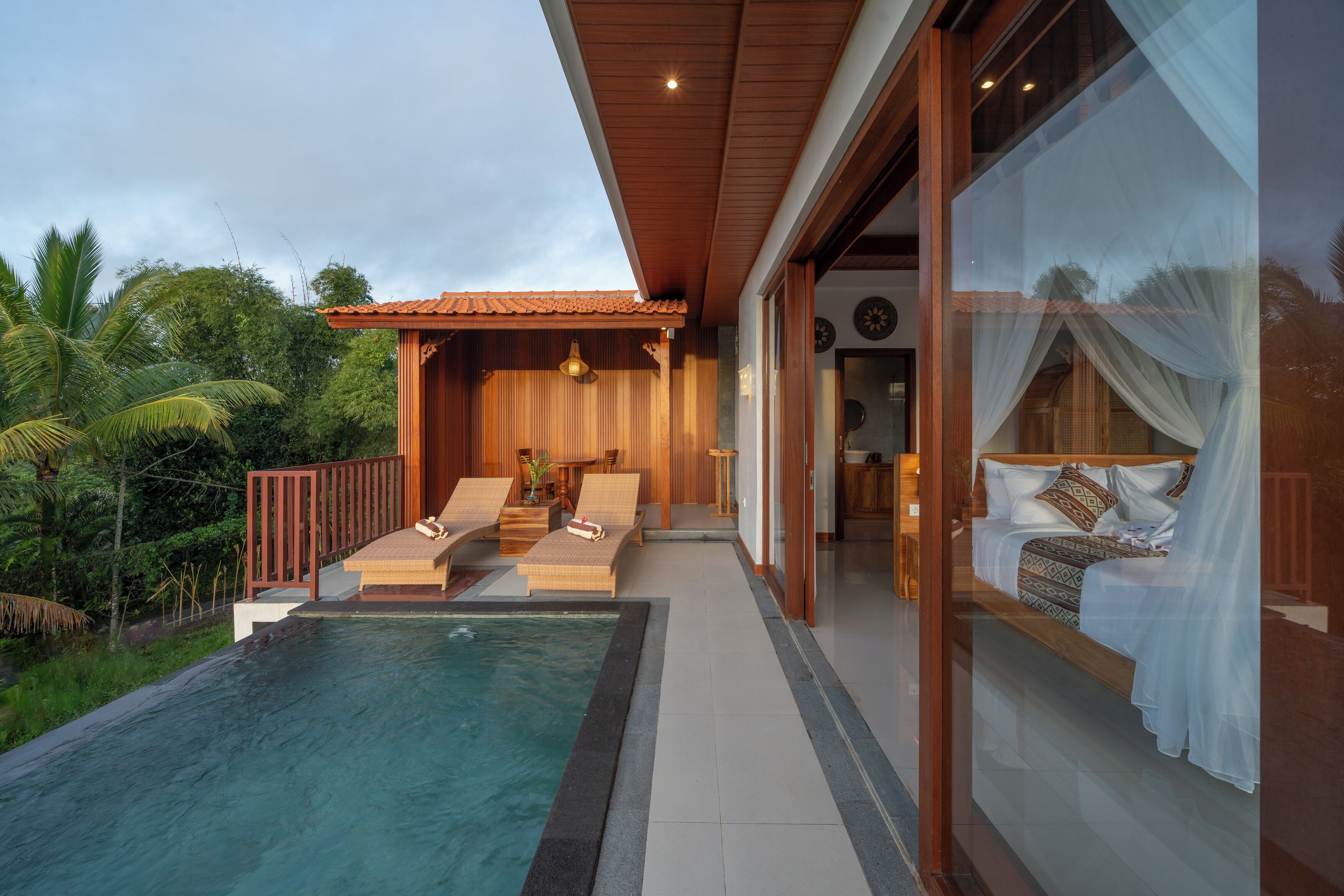 Uma villa moderna com piscina, deck de madeira e um quarto com cama de dossel.