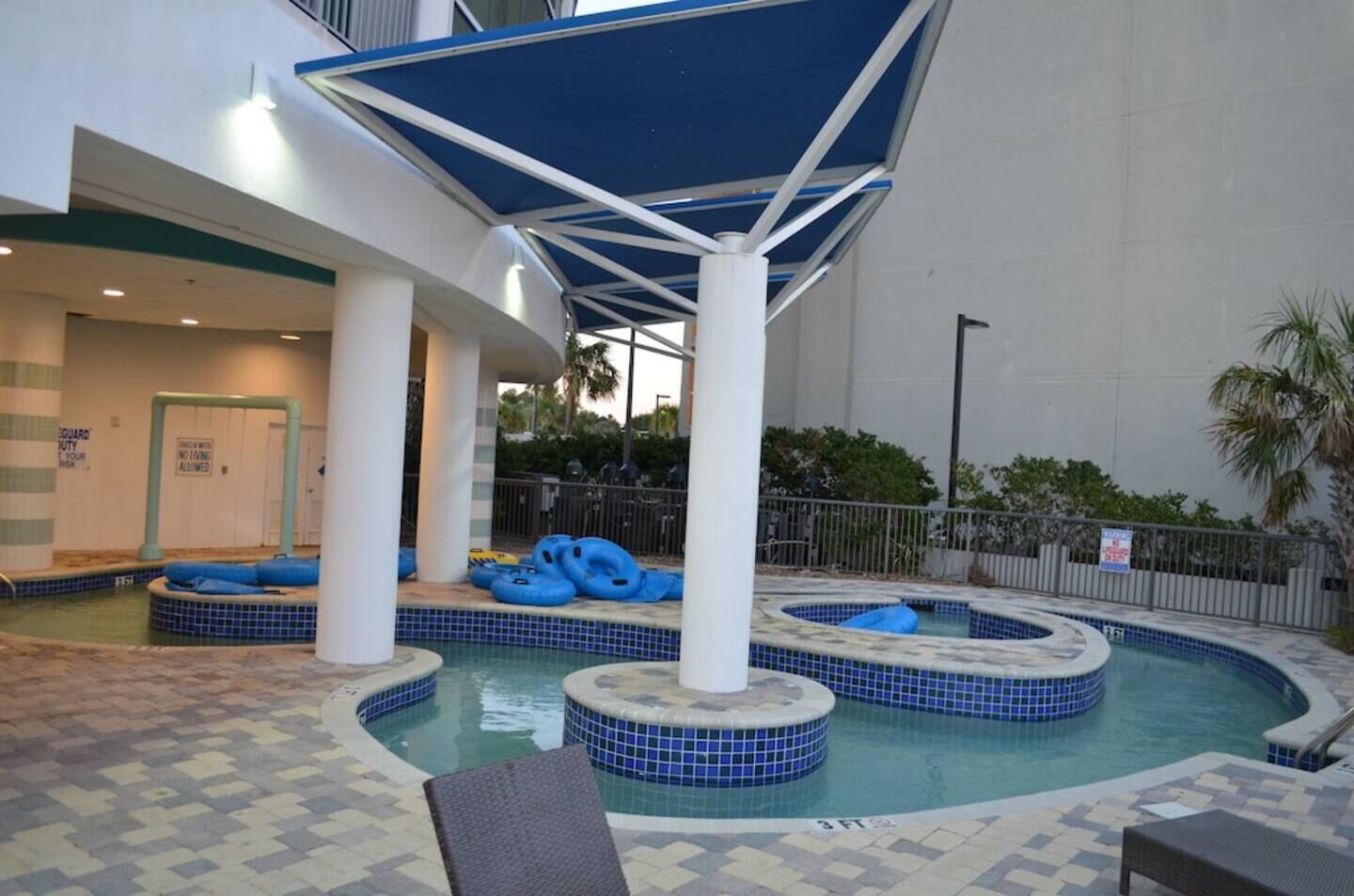 An indoor pool area with multiple hot tubs and lounge chairs.