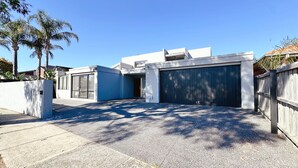A modern residential building with a garage, a covered driveway, and a concrete wall. - Lakefront/View/Swimming Pool/6B4B/Shopping Nearby (Patterson Lakes)