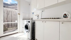 A laundry room with a washing machine, a drying rack, and a countertop with a bottle of Bonistero Sensitive detergent. - Lakefront/View/Swimming Pool/6B4B/Shopping Nearby (Patterson Lakes)