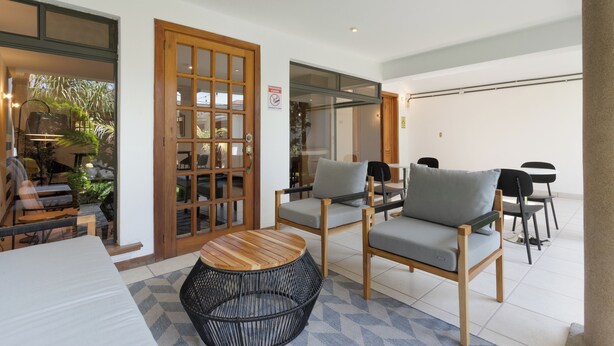 Un espace extérieur moderne, aménagé avec du mobilier en bois, une porte vitrée et offrant une vue sur le jardin.