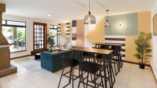 Un espace de restauration moderne offrant différents types de sièges, notamment un canapé et plusieurs tables accompagnées de chaises.