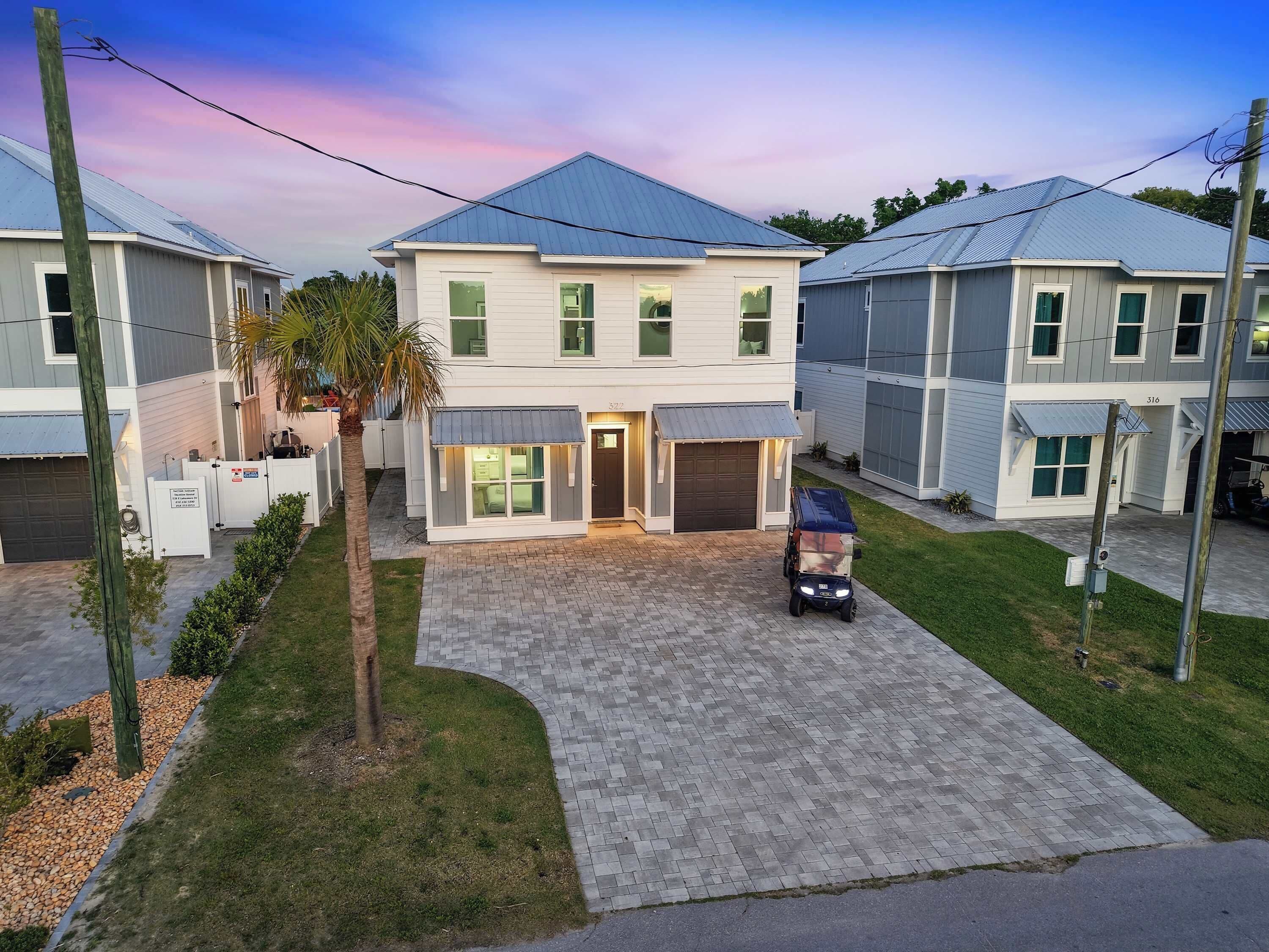 A residential building with a garage, a driveway, and a small vehicle parked in front.