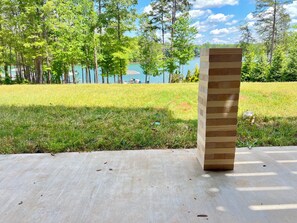 Una estructura de madera en un entorno exterior con un césped y árboles al fondo.