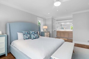 A bedroom with a large bed, bedside tables, a nightstand, a lamp, and a view of the bathroom. - Welcome to Selah by the Sea, your perfectly located Bald Head Island escape (Bald Head Island)