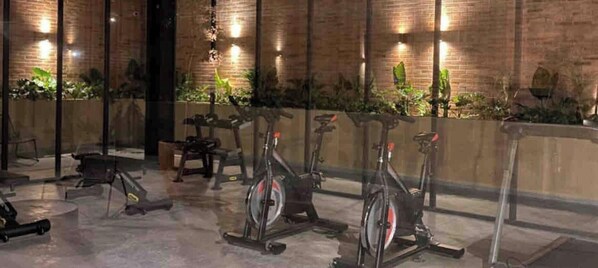 Un gimnasio con bicicletas estáticas, una cinta de correr y equipo de ejercicio.