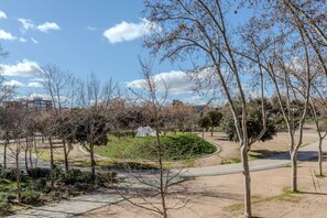 Ein Park mit Wegen, Bäumen und einem Brunnen.