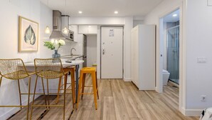 A modern kitchen with a dining area, a white door, and a glass shower area. - Bright and Fantastic Studio - Suitable for Ambassadors (Madrid)