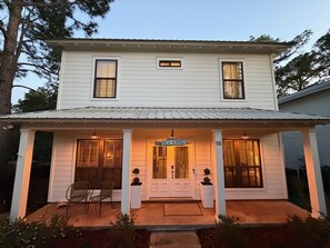 A two-story house with a porch, a sign reading 'SEA GYPSY,' and a number '16' on the front. - Sea Gypsy - 4BR, Walk to Beach and iconic eateries, Pet Friendly, Hot Tub, Bikes (Santa Rosa Beach)