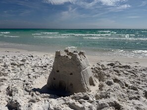 A sandy beach with a sandcastle. - Sea Gypsy - 4BR, Walk to Beach and iconic eateries, Pet Friendly, Hot Tub, Bikes (Santa Rosa Beach)