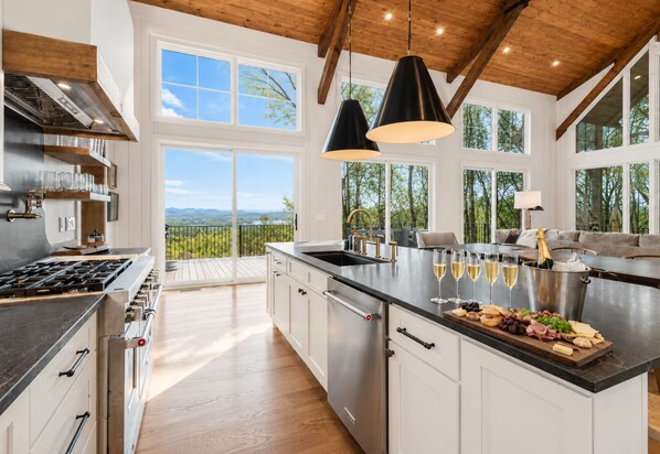 A spacious kitchen with a large island, stainless steel appliances, and a view of the outdoors. - Discover Pool Paradise w/ Breathtaking Lake Views • HotTub • Fun Games • Privacy (Blue Ridge)
