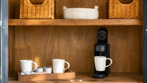 A wooden shelf with wicker baskets, a coffee maker, and white cups. - High Rock Refuge: Pool Paradise w/ Panoramic Views • Hot-Tub • Family Gatherings (Blue Ridge)