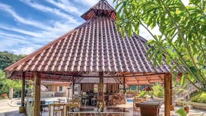 Un espace extérieur abrité comprenant une table de billard, des sièges et une structure en bois.