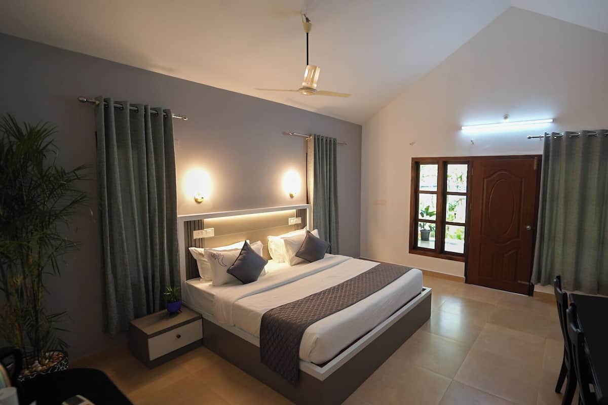 A modern bedroom with a large bed, bedside tables, a ceiling fan, and a view of the outdoors through a window.