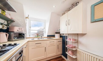 A kitchen with a window, a stove, and cabinets.