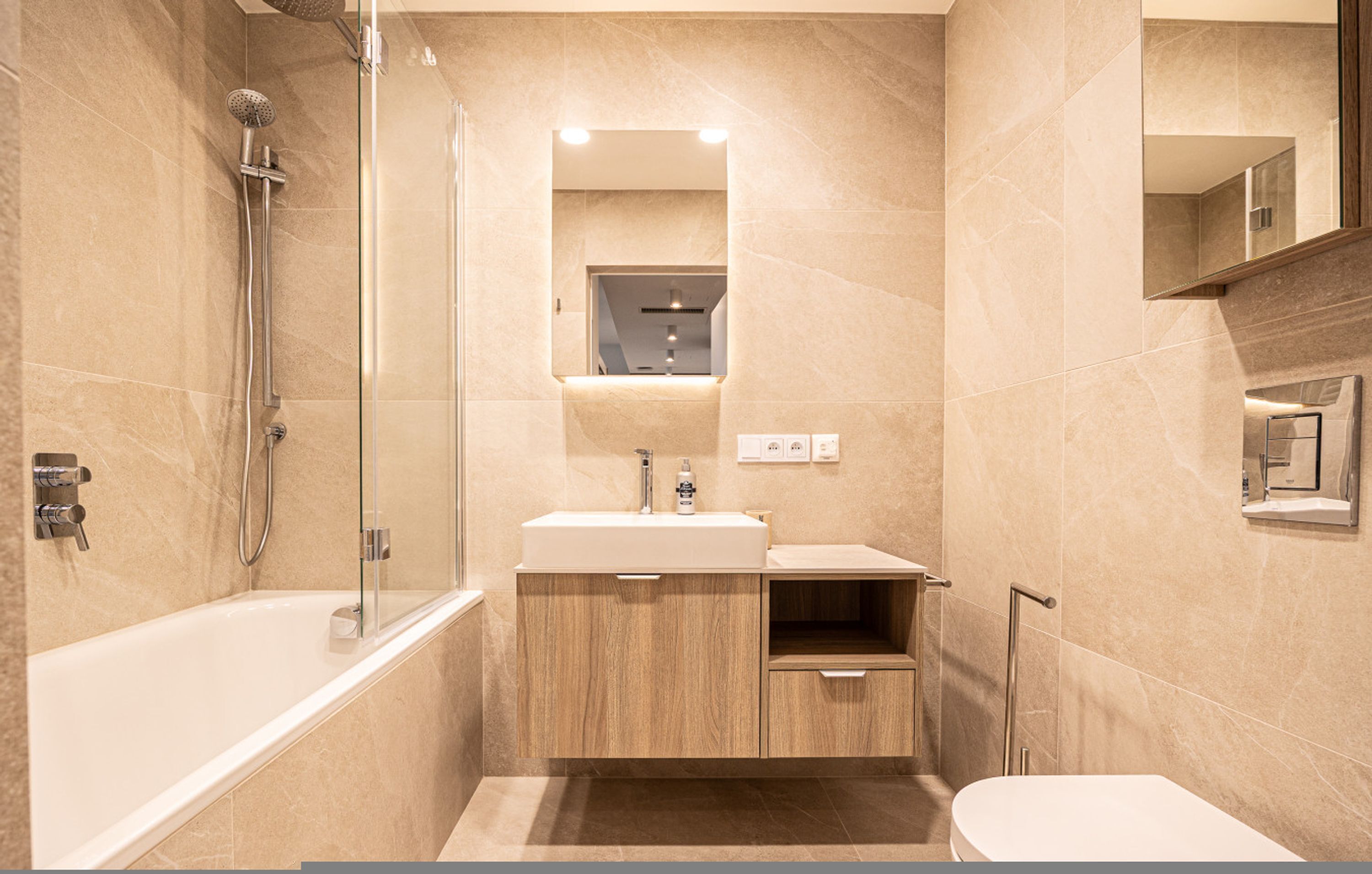 Une salle de bain moderne équipée d’une baignoire, d’une douche, d’un meuble-lavabo et de toilettes.