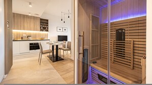 Een moderne keuken met een eetgedeelte, houten lambrisering en een sauna.