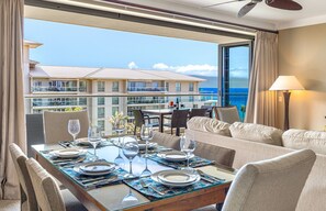 A hotel room with a balcony, a dining table set for two, and a sofa. - Maui Resort Rentals: Honua Kai - 4 Total Bedrooms, Stunning 6th Floor Ocean Views! (Lahaina)