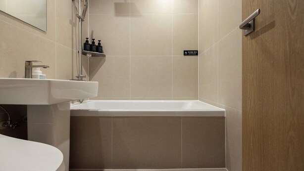 A modern bathroom with a white sink, a bathtub, and a shower area. - Anook Ryokan Hotel Eunpyeong Bulgwang (Seoul)