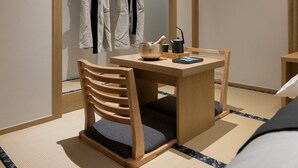A traditional Japanese room with tatami flooring, a low wooden table, a cushioned chair, and a tea set. - Anook Ryokan Hotel Eunpyeong Bulgwang (Seoul)