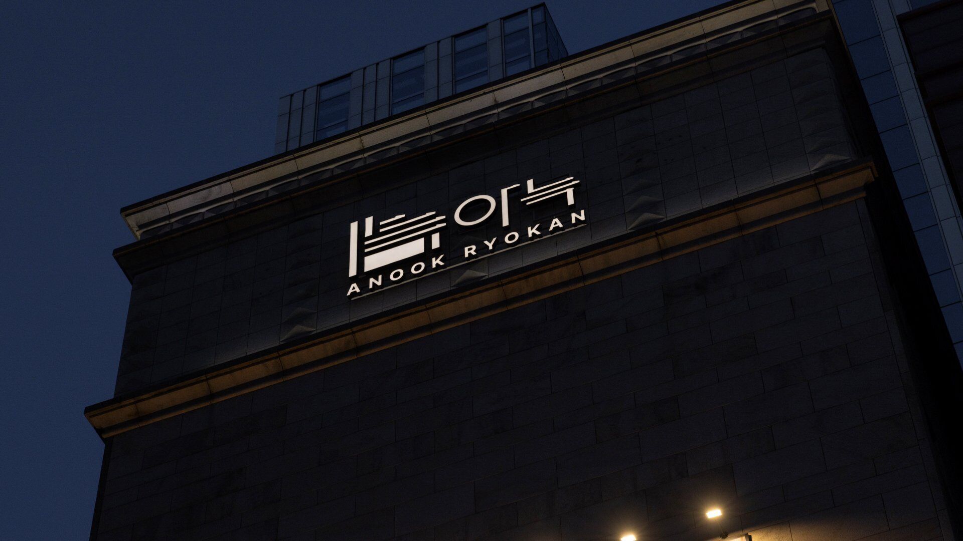 A building with a sign that reads 'ANDOOK RYOKAN'.