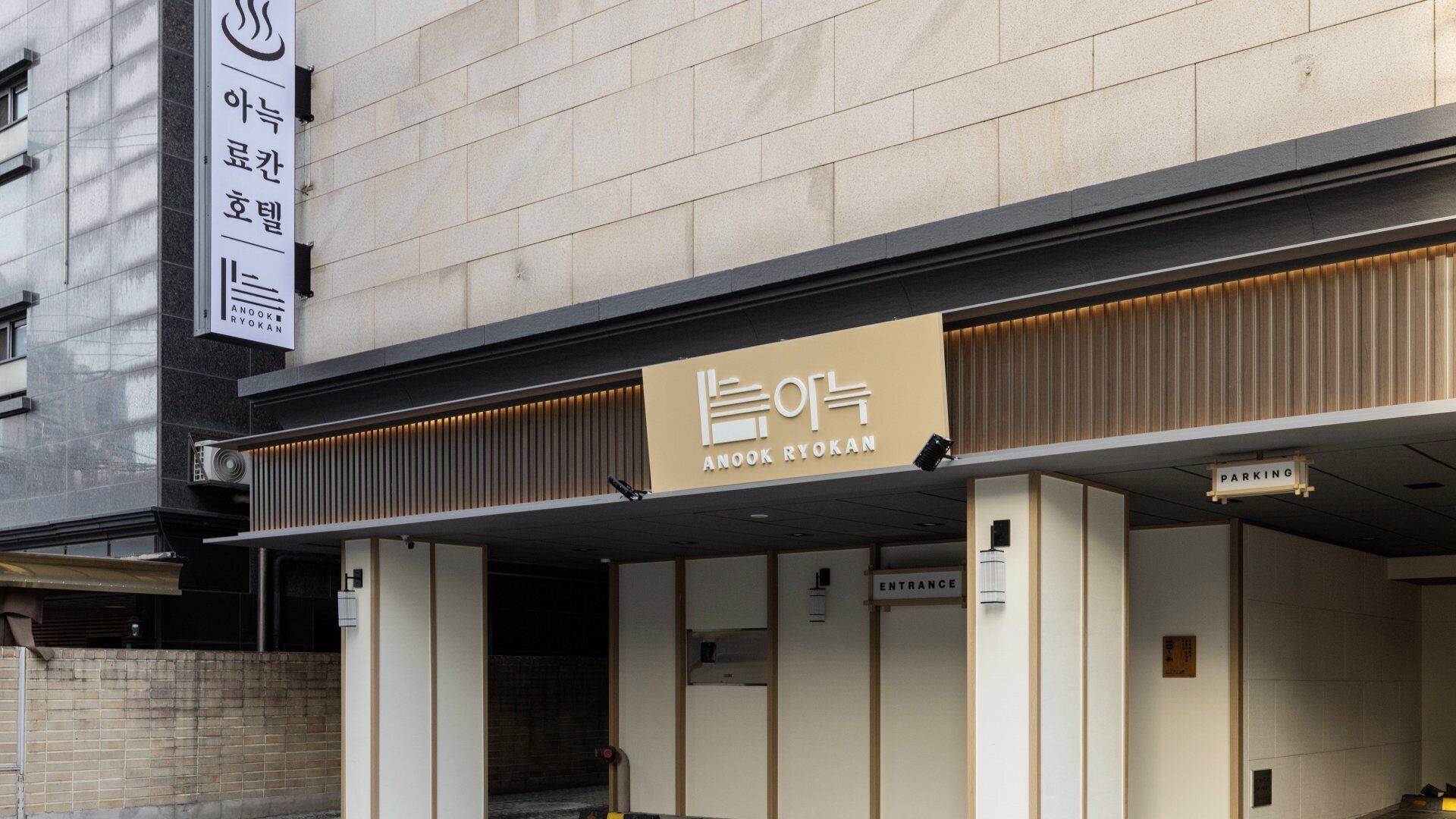 A building with a sign reading 'ANOOK RYOKAN' and an entrance sign.