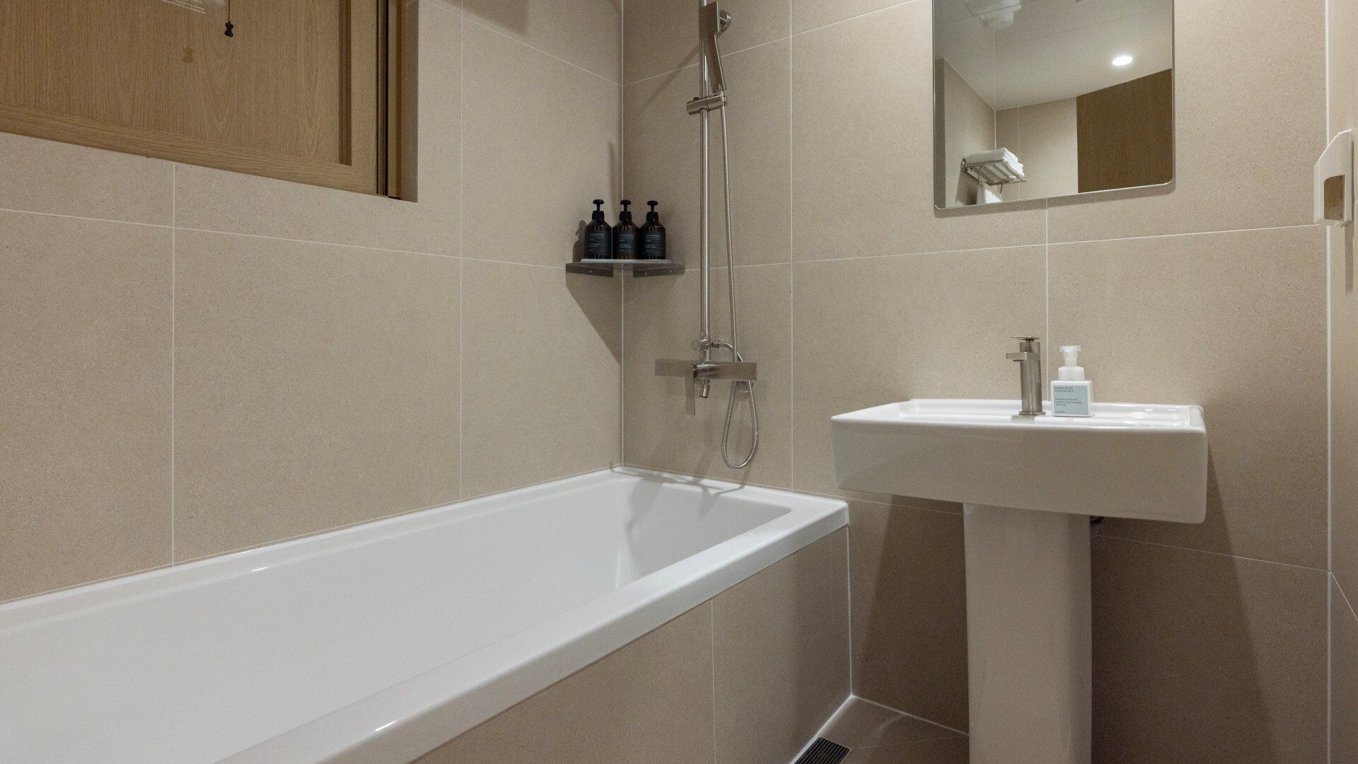 A modern bathroom with a bathtub, shower, and sink.