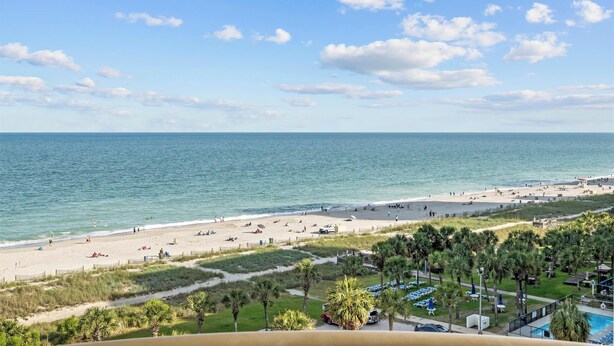 Blick auf einen Strand mit Pool und Palmen.