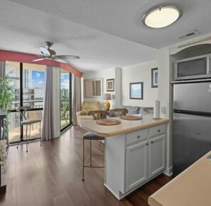 A modern kitchen with a built-in refrigerator, a dining area with a table and chairs, and a balcony with a view. - Myrtle Beach Oceanfront Escape w/Private Balcony - Stunning Beach & City Views (Myrtle Beach)