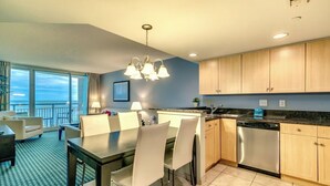 Una cucina moderna con zona pranzo, vista sull'oceano e un balcone.