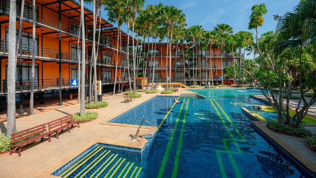 A hotel with a swimming pool, palm trees, and a multi-story building with balconies. - Nongnooch Resort Pattaya (Sattahip)