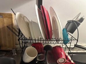 Een keuken met een afwasschaal vol borden en bestek.
