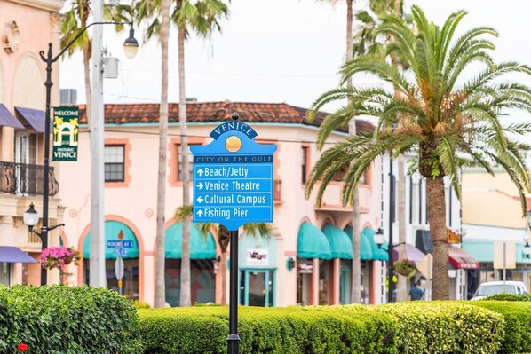 A directional sign with 'Venice' and 'City on the Gulf' text, pointing towards 'Beach/Jetty,' 'Venice Theatre,' 'Cultural Campus,' and 'Fishing Pier.' - Venice Villas Regina - Courtyard - Pool (Venice)