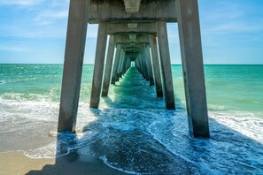 A pier extending into the ocean with waves crashing at the base. - Venice Villas Regina - Courtyard - Pool (Venice)