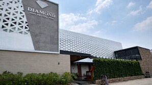 Un hôtel doté d’une façade moderne, d’une enseigne bien visible et d’une entrée agrémentée d’un aménagement paysager.