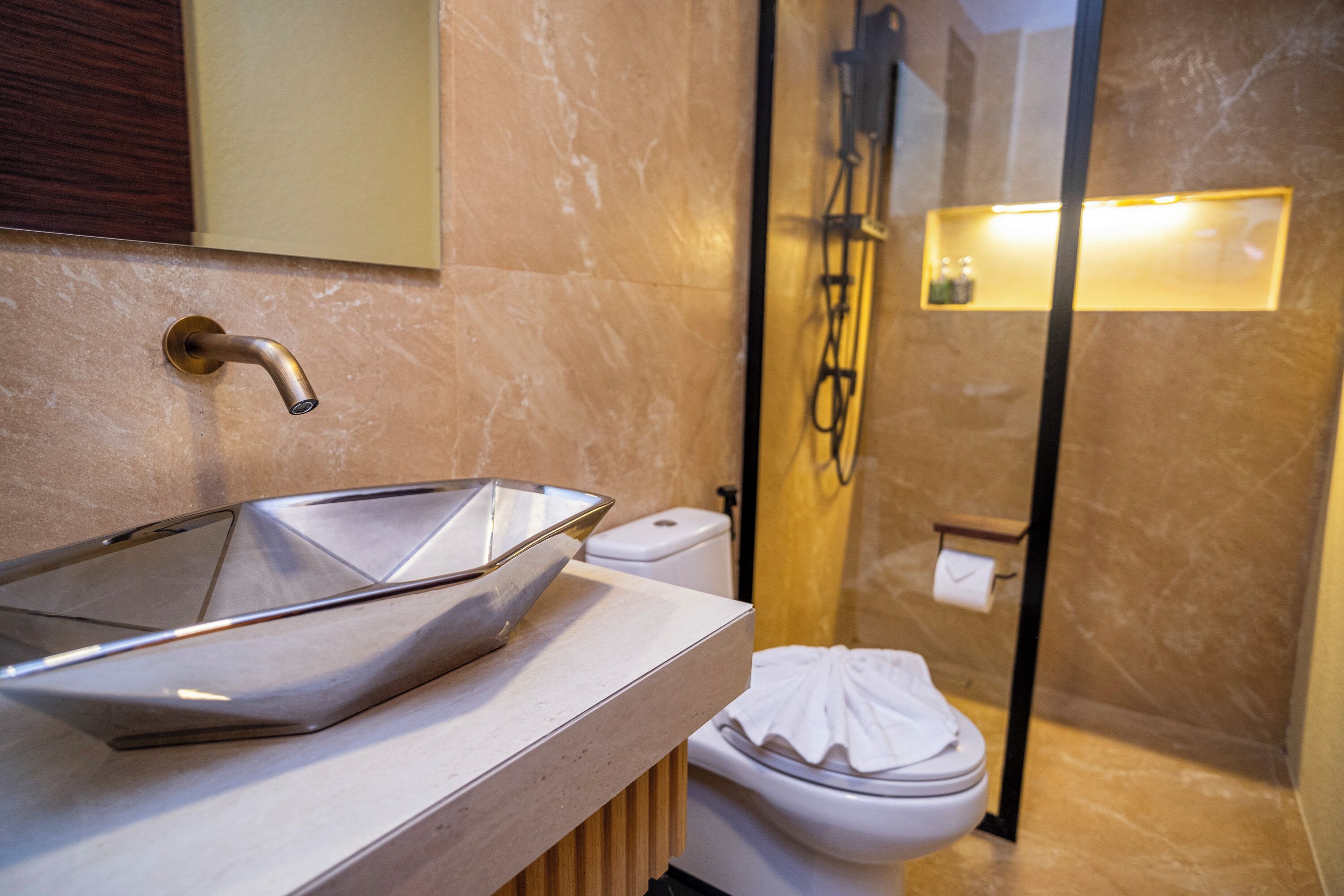 Un baño con un lavamanos moderno, inodoro y ducha.