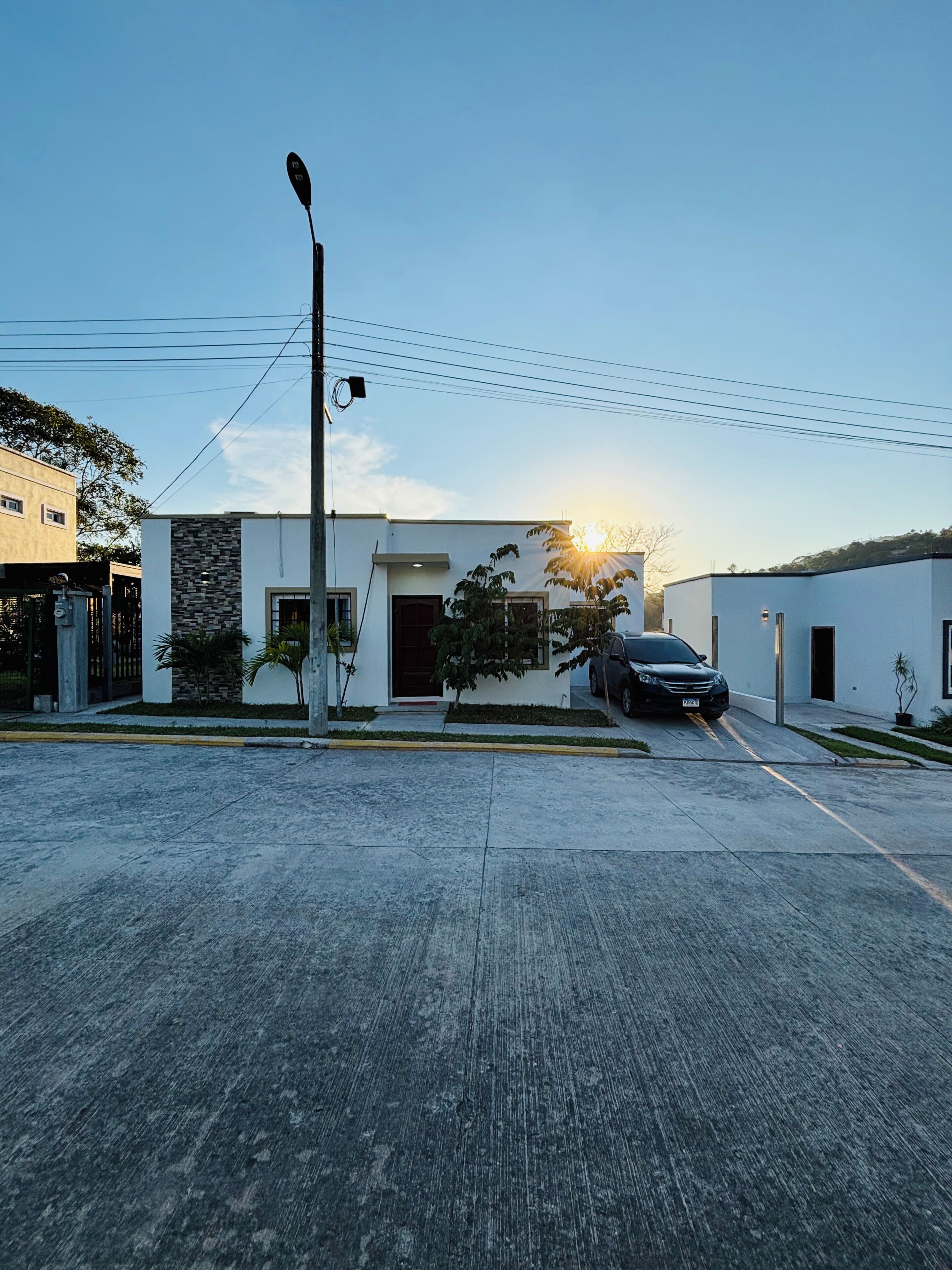 Un bâtiment moderne doté d’un toit plat, d’un garage et d’une voiture garée.
