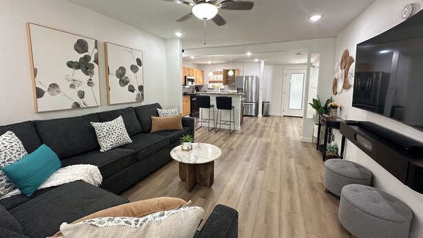 A modern living room with a black sofa, a coffee table, and a TV. - Casa Legacy house — 8 Min Walk to AT&T Stadium, Sleeps 10 (Arlington)