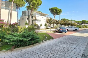 A residential area with modern buildings, a paved walkway, and parked cars. - Perla Holiday Homes 202, Lalzit Bay, Albania (Lalzit Bay)