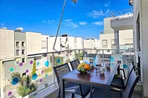 A balcony with a table set for two, a bowl of fruit, and a kettle. - Perla Resort Holiday Homes 200, Lalzit Bay, Albania (Lalzit Bay)