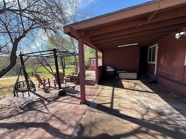 A covered patio with outdoor seating, a grill, and a shed. - Sedona Retreat Walk to Park, Hikes & Sunset Views (Sedona)