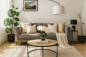 A living room with a sofa, a coffee table, a lamp, and potted plants. - Luxury Sanctuary in Central Shoreditch: 3 Beds (London)