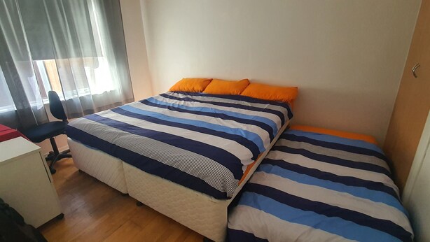 Une chambre à coucher avec un lit, un bureau et une chaise.