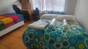 Une chambre d’hôtel avec un lit, un bureau, une chaise et une fenêtre donnant sur un paysage agréable.