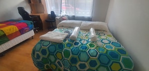 A hotel room with a bed, a desk, a chair, and a window with a view.